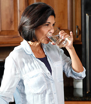 Mujer bebiendo un vaso de agua.